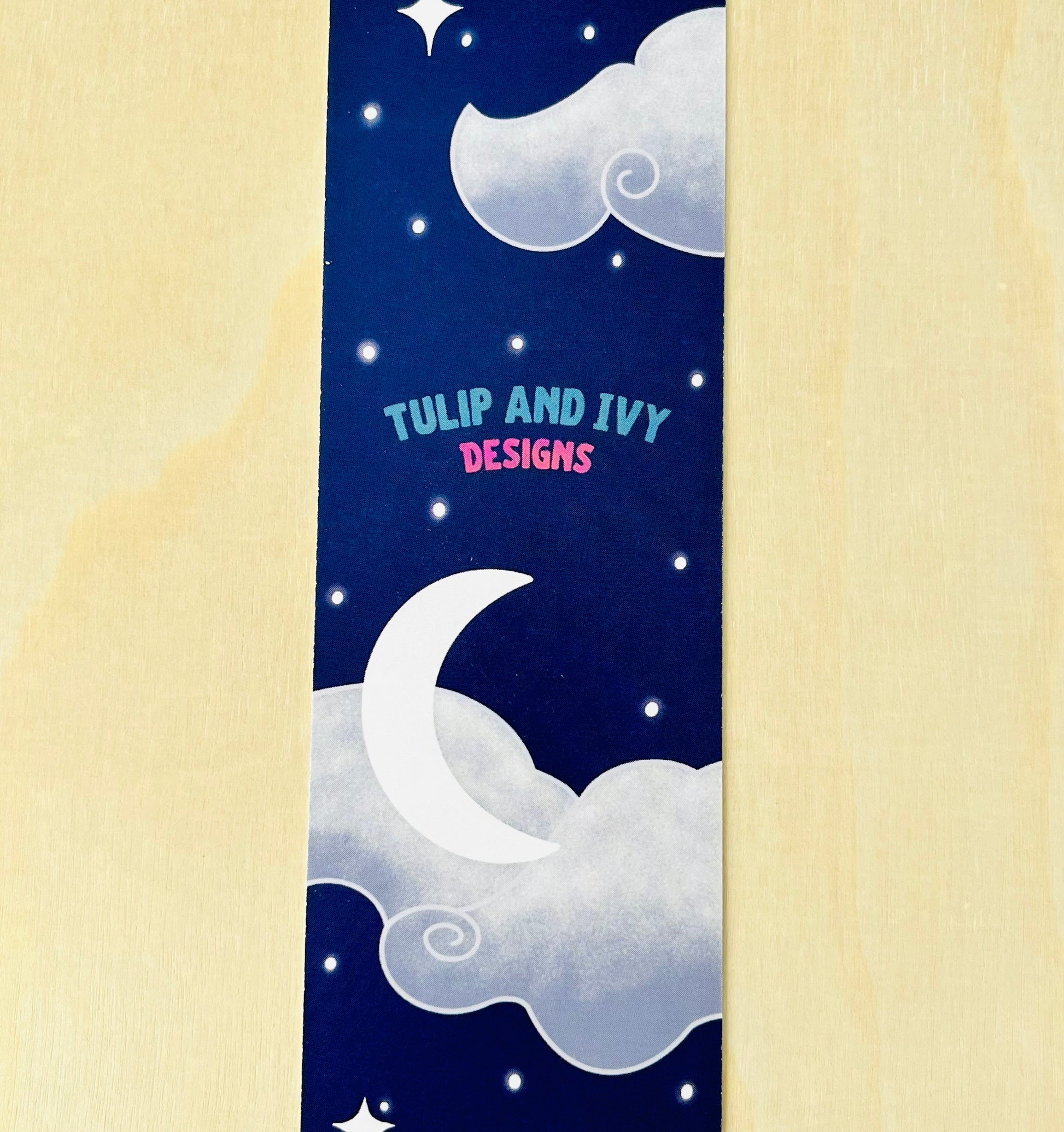 Bookmark with moon and star design on a blue background, featuring 'Tulip and Ivy Designs'.